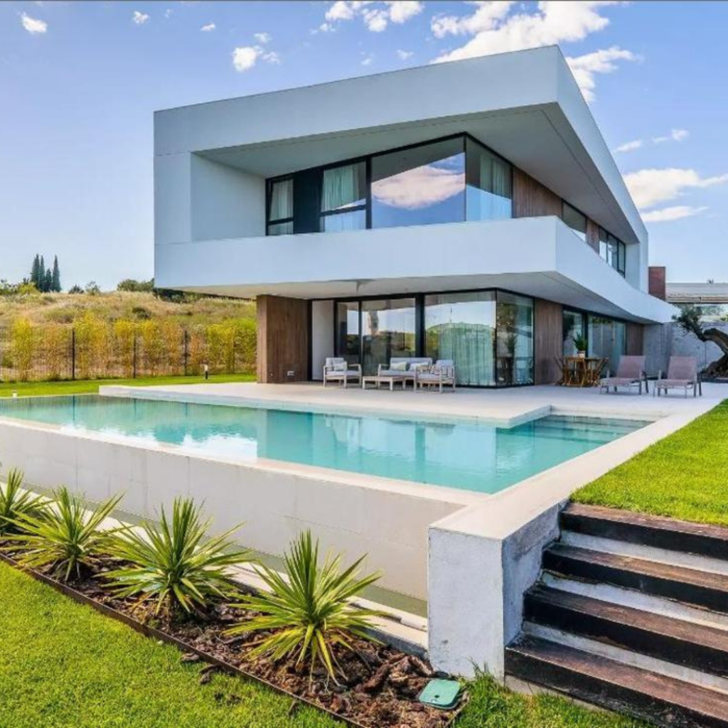 Chalet blanco con piscina, con césped verde